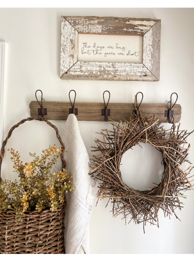 Peg rack with wreath, grain sack and a basket with faux greenery