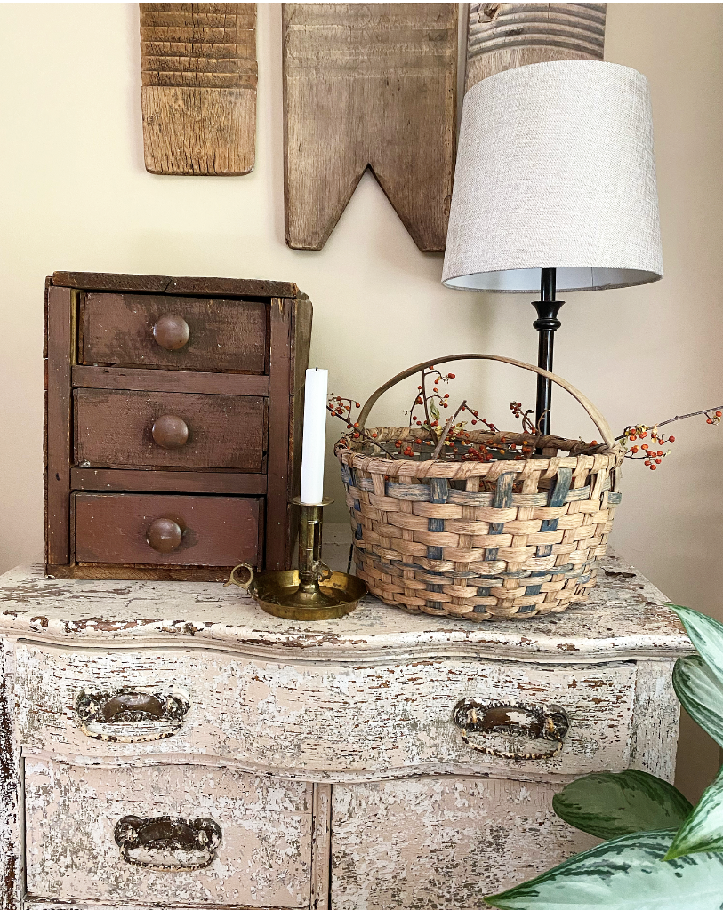 Vintage basket with bittersweet on a cabinet with an brass candle holder