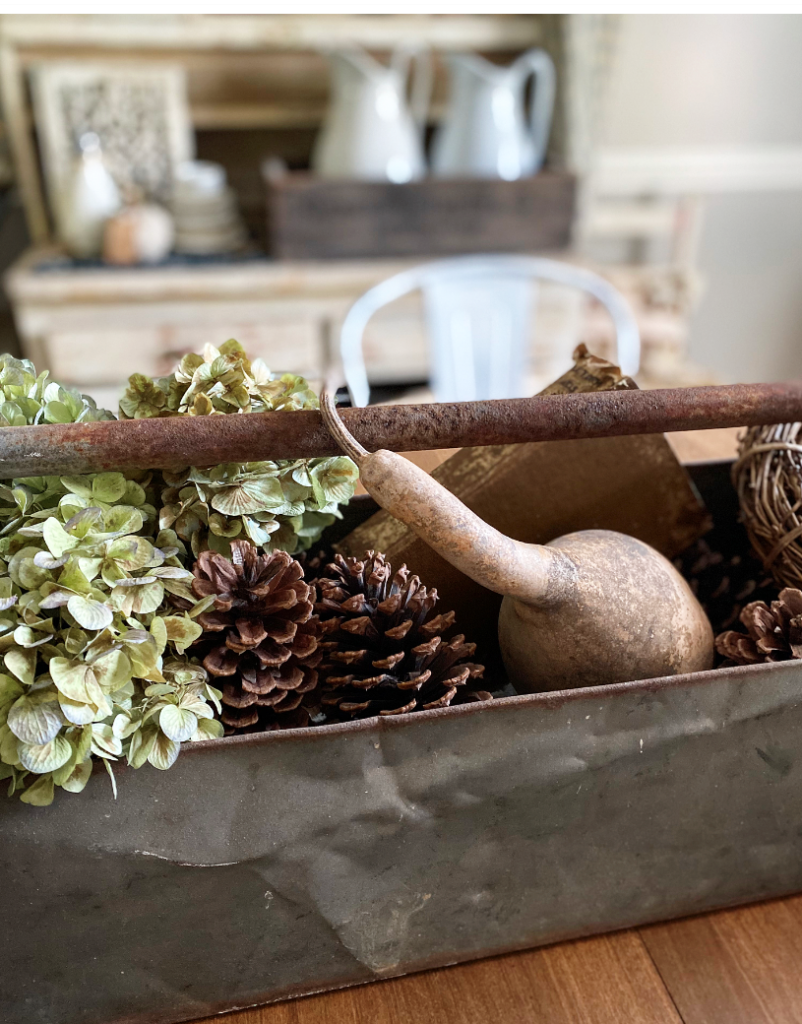 Toolbox centerpiece with hydrangeas and a gourd