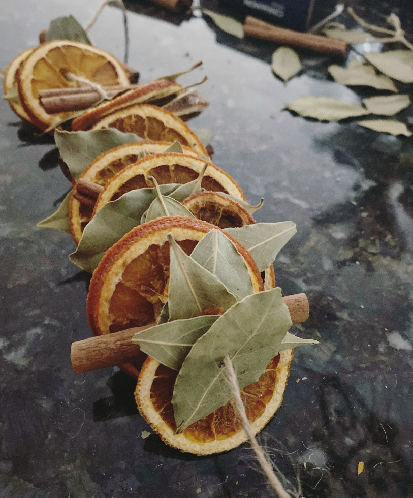 dried oranges, bay leaves, cinnamon sticks and twine all in a pattern